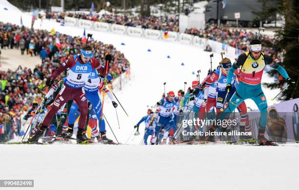 Anton Schipulin of Russia and Martin Fourcade of France lead the field as they come up the hill to the shooting range during the men's mass start...