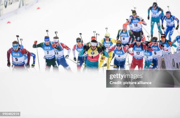 Anton Schipulin of Russia Simon Schempp of Germany and Martin Fourcade of France lead the field as they come up the slope to the shooting range...