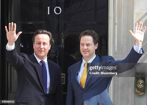 David Cameron, U.K. Prime minister, left, and Nick Clegg, U.K. Deputy prime minister, wave to the media from the steps of 10 Downing Street, in...