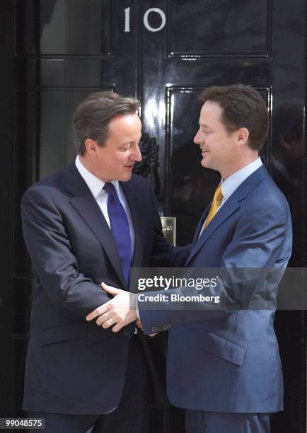 David Cameron, U.K. Prime minister, left, greets Nick Clegg, U.K. Deputy prime minister, on the steps of 10 Downing Street, in London, U.K., on...