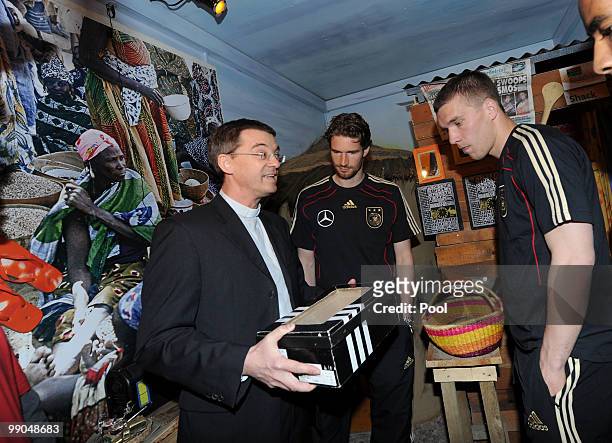 President of Missio Klaus Kraemer talks to players of team Germany Lukas Podolski and Arne Friedrich during their visit of the Missio-Aidstruck on...