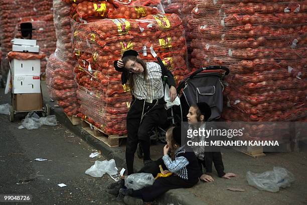Ultra-Orthodox Jewish children wait at the food for the poor distribution center at their conservative neighbourhood in Jerusalem on March 25, 2010....