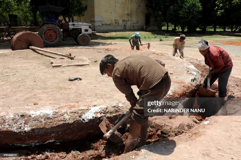 Indian labourers prepare the ground for