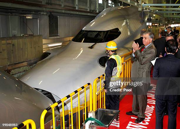 Transportation Secretary Ray LaHood applauds as two types of bullet trains are connected during a demonstration at Shinkansen Vehicle Center of East...