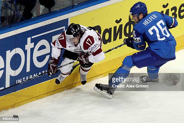 Aleksandrs Nizivijs of Latvia is challenged by Armin Helfer of Italy during the IIHF World Championship group C match between Italy and Latvia at SAP...