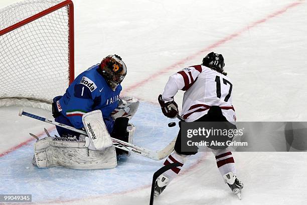 Goalkeeper Adam Russo of Italy makes a save against Aleksandrs Nizivijs of Latvia during the IIHF World Championship group C match between Italy and...