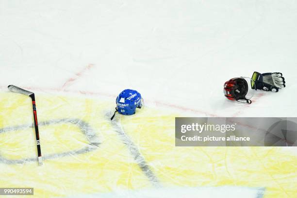 Ice hockey helmets, a glove and ice hockey stick lie on the floor during a fight between players at the SAP-Arena in Mannheim, Germany, 14 January...