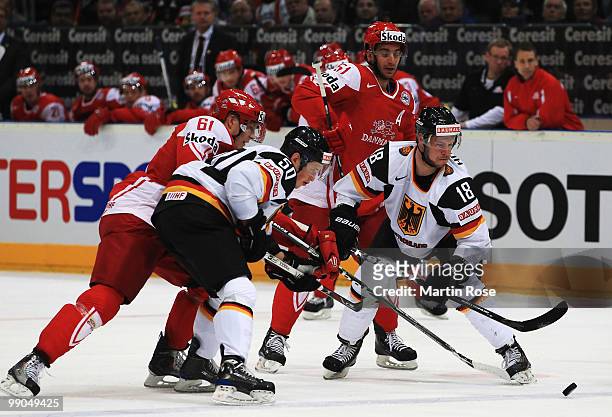 Lars Eller and Frans Nielsen of Denmark and Patrick Hager and Kai Hospelt of Germany battle for the puck during the IIHF World Championship group A...