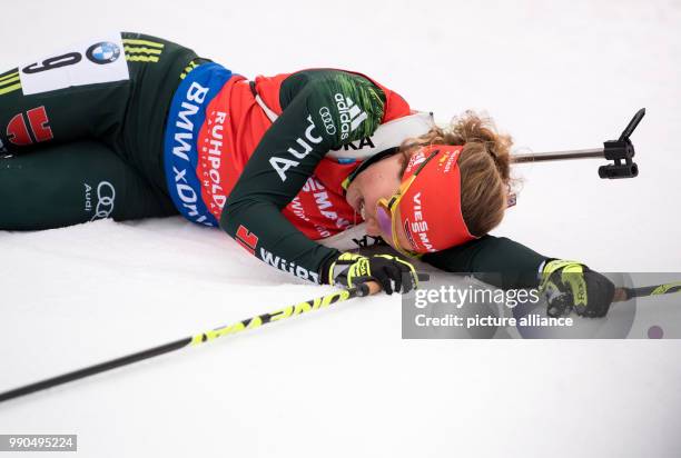 Laura Dahlmeier of Germany lying on the ground at the finish during the women's mass start event of the Biathlon World Cup at the Chiemgau Arena in...