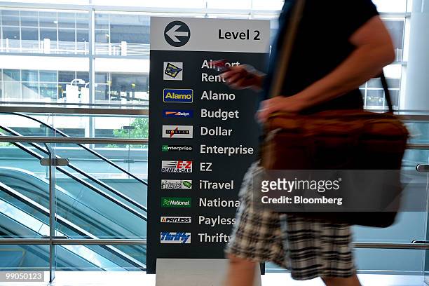 Traveler walks past a sign displaying the various car-rental companies at Hartsfield-Jackson Atlanta International Airport in Atlanta, Georgia, U.S.,...