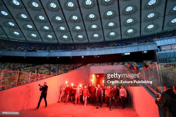 Activists carry burning flares as they enter the stands of the NSC Olimpiyskiy during the Oleh, Ukraina z toboiu! action held in support of Ukrainian...
