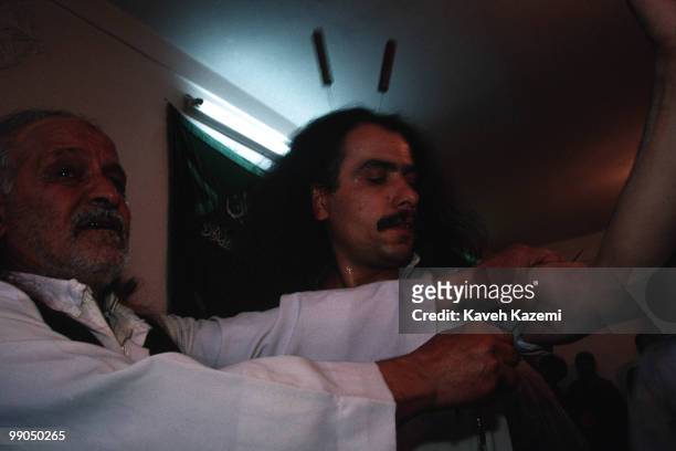 During remembrance ceremony a Kasnazani dervish, while in trance, has two knives in his skull and one skewer being put through his arms by the Shaikh...