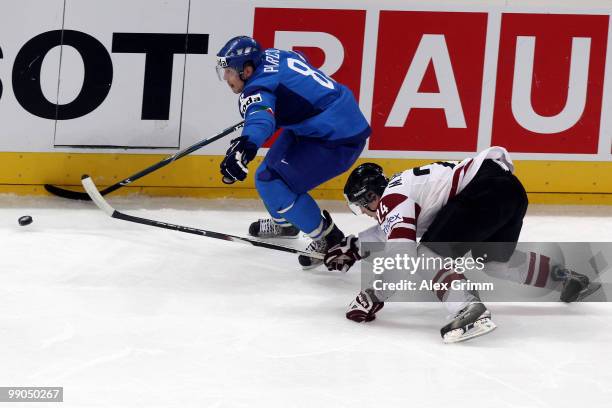 Nicholas Plastino of Italy eludes Mikelis Redlihs of Latvia during the IIHF World Championship group C match between Italy and Latvia at SAP Arena on...