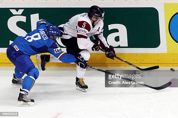 Janis Sprukts of Latvia is challenged by John Parco of Italy during the IIHF World Championship group C match between Italy and Latvia at SAP Arena...