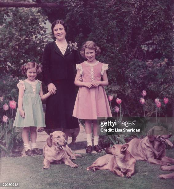 The Queen Mother with Princess Margaret and Princess Elizabeth standing in the grounds of the Royal Lodge in Windsor in England circa June 1936.