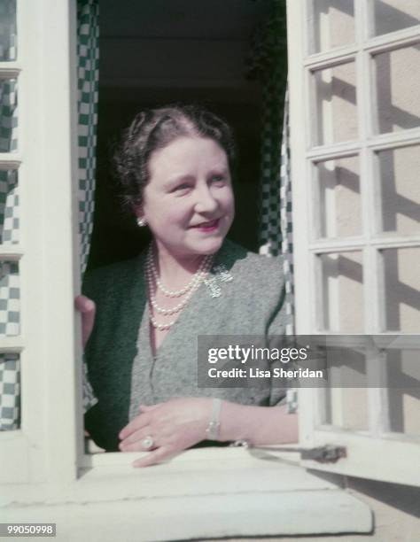 The Queen Mother at a window in the little Welsh house at the Royal Lodge in Windsor in England, circa 1954.