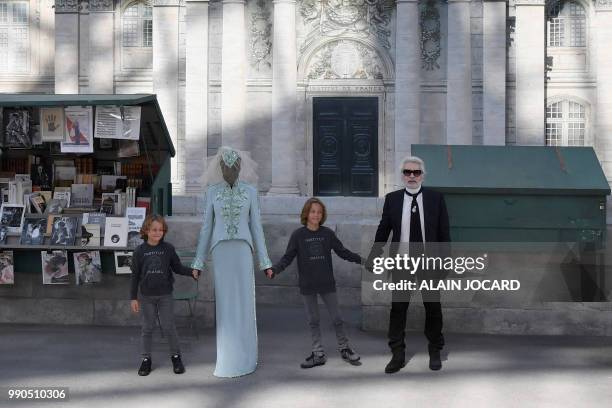 German fashion designer Karl Lagerfeld , flanked by his godson Hudson Kroenig and South Sudanese-Australian model Adut Akech acknowledges the...