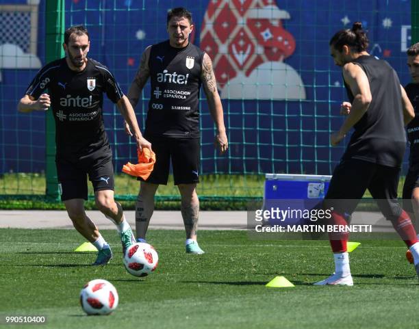 Uruguay's defender Diego Godin , Uruguay's midfielder Cristian Rodriguez and Uruguay's defender Martin Caceres attend a training session at the Sport...