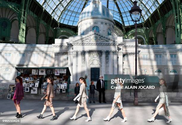 German fashion designer Karl Lagerfeld , flanked by his godson Hudson Kroenig acknowledges the audience at the end of the Chanel 2018-2019...