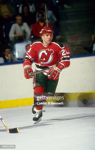 George McPhee of the New Jersey Devils skates on the ice against the New York Islanders during an NHL game circa 1987 at the Nassau Coliseum in...