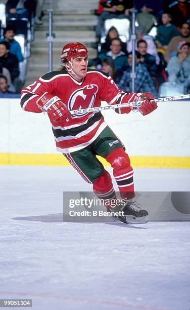 George McPhee of the New Jersey Devils skates on the ice against the New York Islanders during an NHL game circa 1987 at the Nassau Coliseum in...