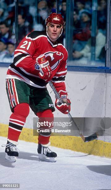 George McPhee of the New Jersey Devils skates on the ice against the New York Islanders during an NHL game circa 1987 at the Nassau Coliseum in...