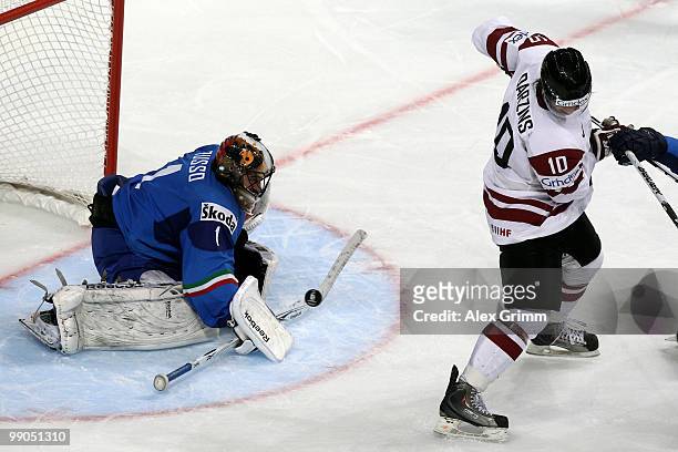 Goalkeeper Adam Russo of Italy is challenged by Lauris Darzins of Latvia during the IIHF World Championship group C match between Italy and Latvia at...