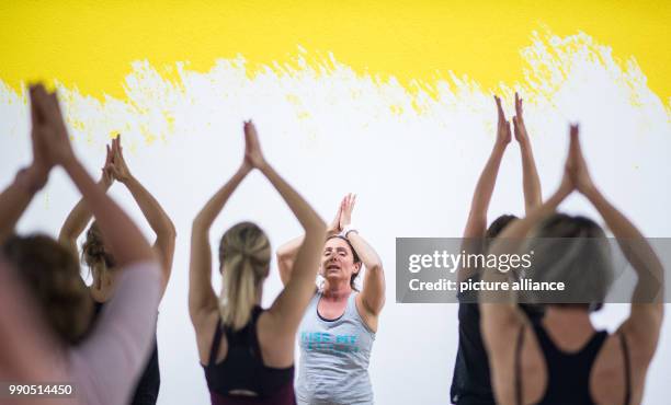 Women practice yoga during a yoga course in front of the art work Trevira of Leni Hoffman at the Gallery Stadt Sindelfingen in Sindelfingen, Germany,...