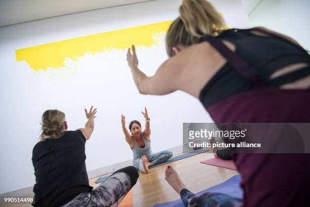 Women practice yoga during a yoga course in front of the art work Trevira of Leni Hoffman at the Gallery Stadt Sindelfingen in Sindelfingen, Germany,...