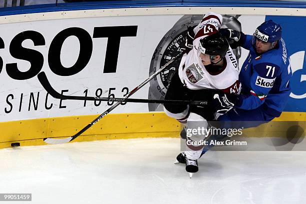 Martins Cipulis of Latvia is challenged by Luca Ansoldi of Italy during the IIHF World Championship group C match between Italy and Latvia at SAP...