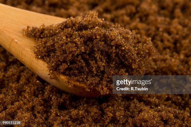 brown muscovado sugar in wooden spoon on the sugar background - anatomical substance imagens e fotografias de stock
