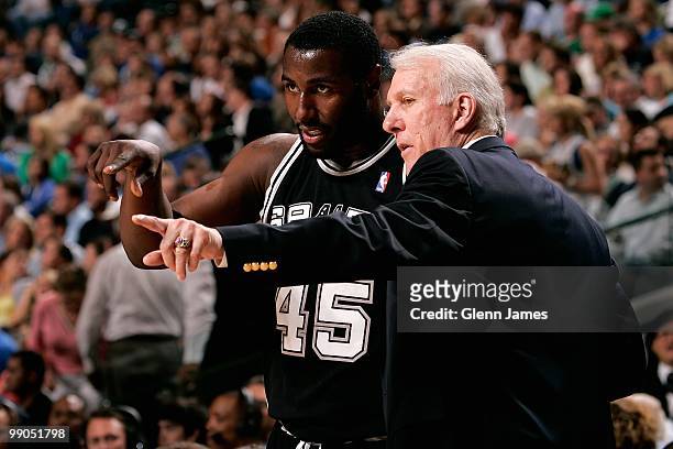 DeJuan Blair talks to head coach Gregg Popovich of the San Antonio Spurs walks along the side line in Game Five of the Western Conference...