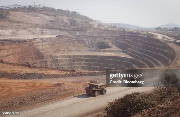 Caterpillar Inc. Mining truck drives past an open pit excavation at the Mutanda copper and cobalt mine in Mutanda, Katanga province, Democratic...