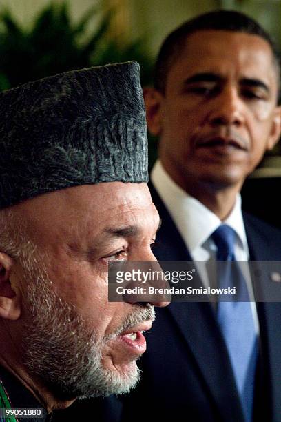 President Barack Obama listens while Afghanistan President Hamid Karzai speaks during a joint press conference in the East Room of the White House...