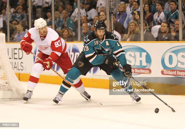 Joe Thornton of the San Jose Sharks skates with the puck against Johan Franzen of the Detroit Red Wings in Game Five of the Western Conference...