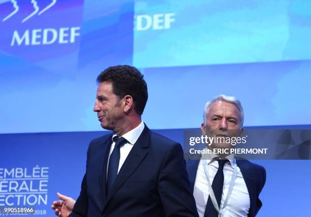 Newly elected President of Medef Geoffroy Roux de Bezieux and former candidate Patrick Martin stand on stage at the end of the French employers'...