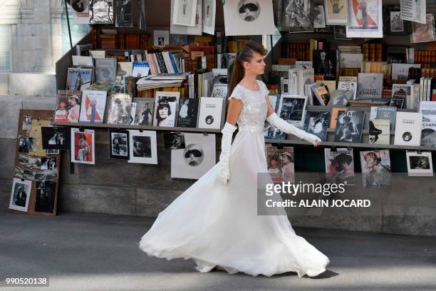 Model presents a creation by Chanel along a replica of Parisian open-air book stalls at the Grand Palais in Paris, during the 2018-2019 Fall/Winter...