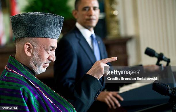 President Barack Obama watches as Afghanistan President Hamid Karzai takes a question during a joint press conference in the East Room of the White...