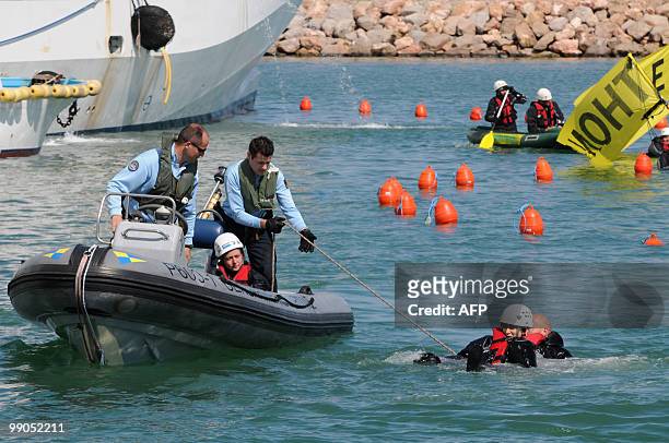 Policemen on a zodiac pull out Greenpeace activists from the water as they block Tuna fishing boats in the harbour of Frontignan, near Montpellier,...