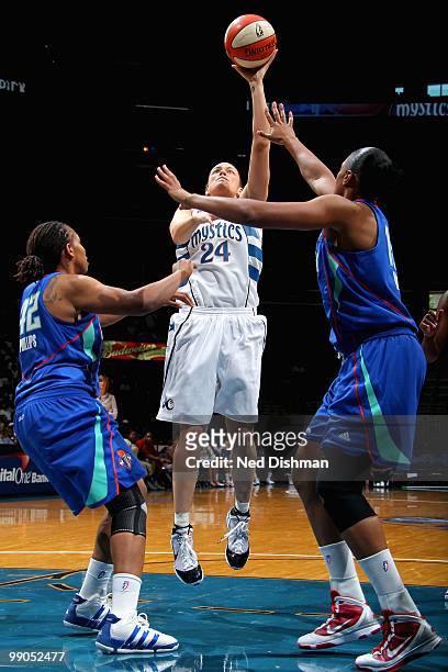 Kristen Mann of the Washington Mystics puts a shot up over April Phillips and Kia Vaughn of the New York Liberty during the WNBA preseason game on...