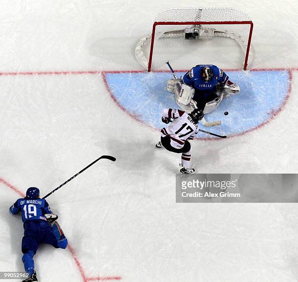 Matthew de Marchi of Italy watches Aleksandrs Nizivijs of Latvia trying to score against goalkeeper Adam Russo of Italy during the IIHF World...