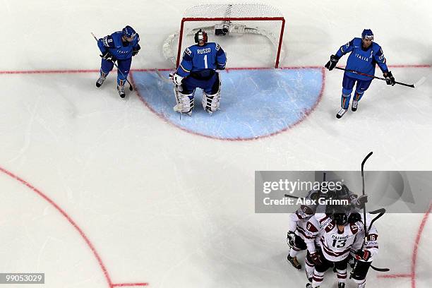 Players of Latvia celebrate a goal as John Parco, goalkeeper Adam Russo and Michele Strazzabosco of Italy react during the IIHF World Championship...