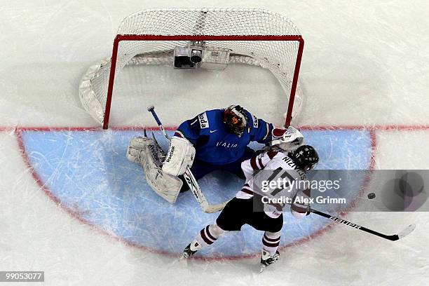 Aleksandrs Nizivijs of Latvia tries to score against goalkeeper Adam Russo of Italy during the IIHF World Championship group C match between Italy...