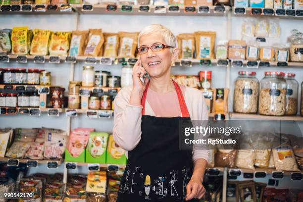 gelukkig oude vrouw met behulp van mobiele telefoon in de winkel - happy mobile stockfoto's en -beelden