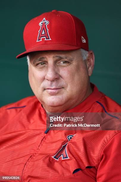 Manager Mike Scioscia of the Los Angeles Angels of Anaheim sits in the dugout during batting practice before a game against the Baltimore Orioles at...