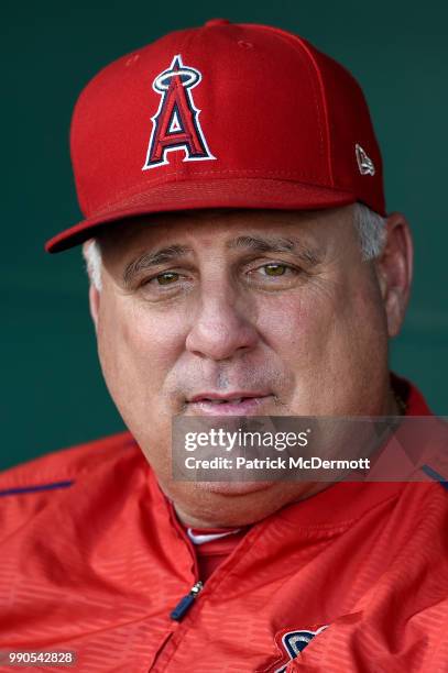 Manager Mike Scioscia of the Los Angeles Angels of Anaheim sits in the dugout during batting practice before a game against the Baltimore Orioles at...