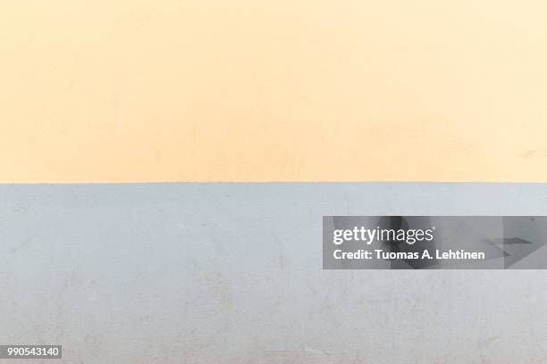 full frame background of an old concrete wall painted in light yellow and gray - yellow light effect stock pictures, royalty-free photos & images