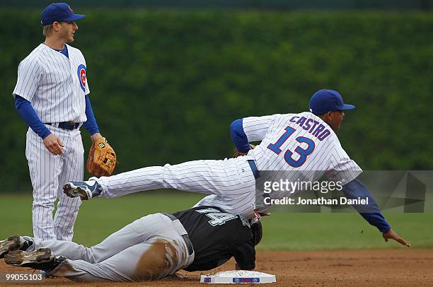 Starlin Castro of the Chicago Cubs lands on Gaby Sanchez of the Florida Marlins after turning a double play in the first inning in front of teammate...