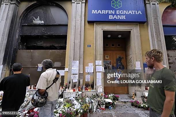 People look at messages left in front of the burnt Marfin bank where three people died on May 5, in central Athens, during a protest, on May 12,...