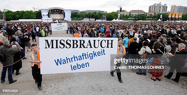 Believers carry a banner reading "Abuse - live truthfulness" during the opening service of the second Oecumenic Church Congress on May 12, 2010 in...